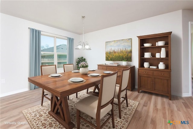 dining room featuring light hardwood / wood-style flooring and a chandelier