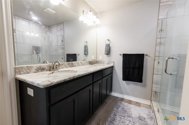 bathroom with vanity, hardwood / wood-style flooring, and a shower with shower door