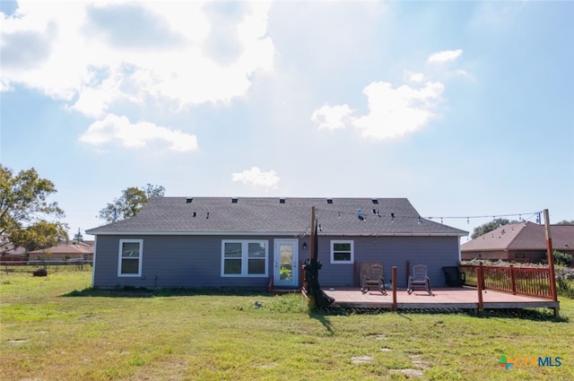 back of house featuring a deck and a lawn