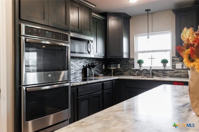 kitchen featuring sink, hanging light fixtures, tasteful backsplash, dark brown cabinets, and stainless steel appliances