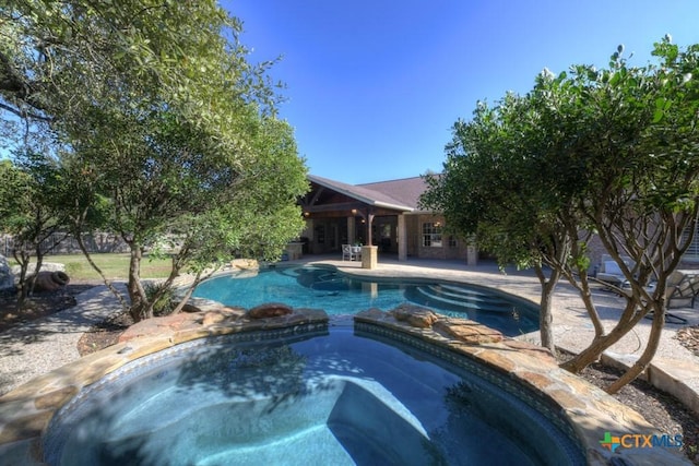 view of pool with an in ground hot tub