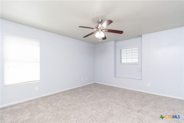 empty room with carpet floors, ceiling fan, and baseboards