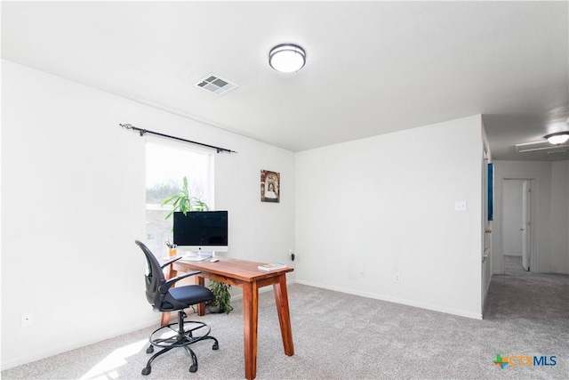 carpeted office featuring visible vents and baseboards