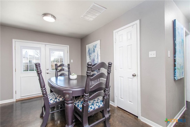 dining room with finished concrete floors, french doors, visible vents, and baseboards