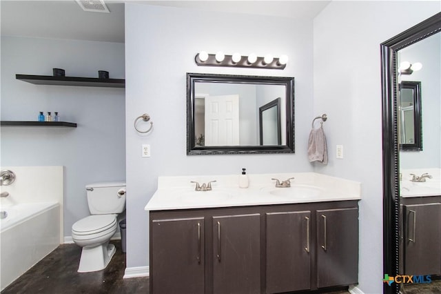 bathroom featuring double vanity, a tub to relax in, a sink, and toilet