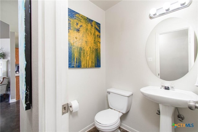 bathroom featuring toilet and baseboards