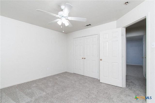 unfurnished bedroom featuring ceiling fan, a closet, visible vents, and carpet flooring