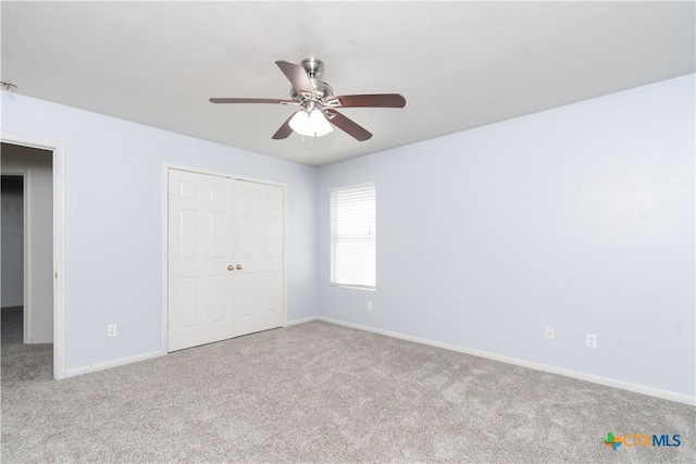 unfurnished bedroom with carpet floors, a closet, ceiling fan, and baseboards