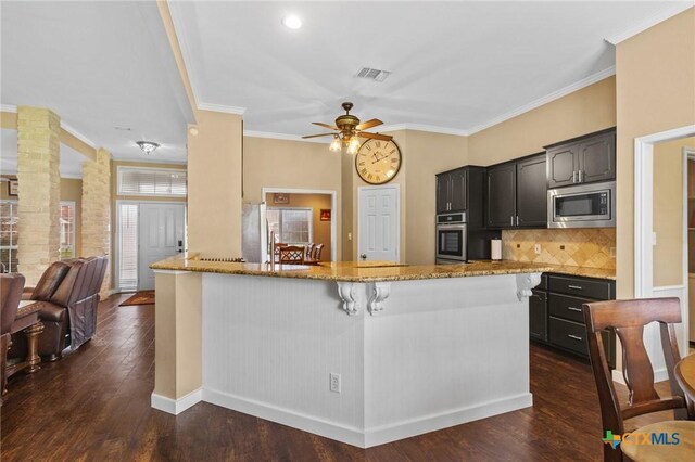 204 Crosswind Dr, Victoria, TX 77904 - kitchen with appliances with stainless steel finishes, light stone countertops, crown molding, ceiling fan, and dark wood-type flooring
