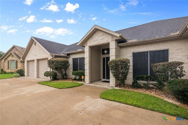 204 Crosswind Dr, Victoria, TX 77904 - view of front facade featuring a shingled roof, a garage, concrete driveway, and brick siding