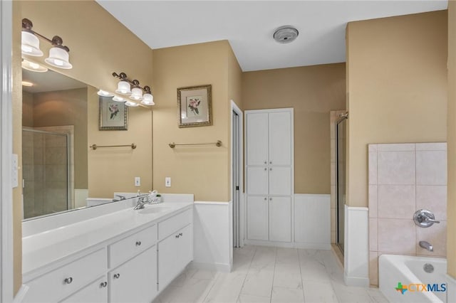 204 Crosswind Dr, Victoria, TX 77904 - full bathroom featuring marble finish floors, vanity, a bath, wainscoting, and a stall shower