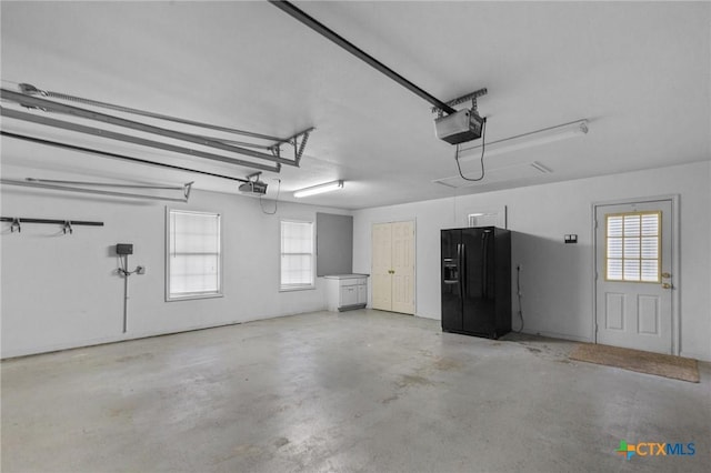 204 Crosswind Dr, Victoria, TX 77904 - garage featuring black refrigerator with ice dispenser and a garage door opener