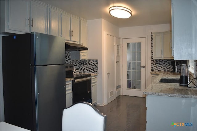 kitchen featuring appliances with stainless steel finishes, light stone countertops, decorative backsplash, and dark tile patterned floors