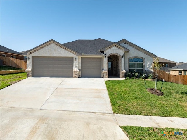 view of front of property featuring a garage and a front lawn