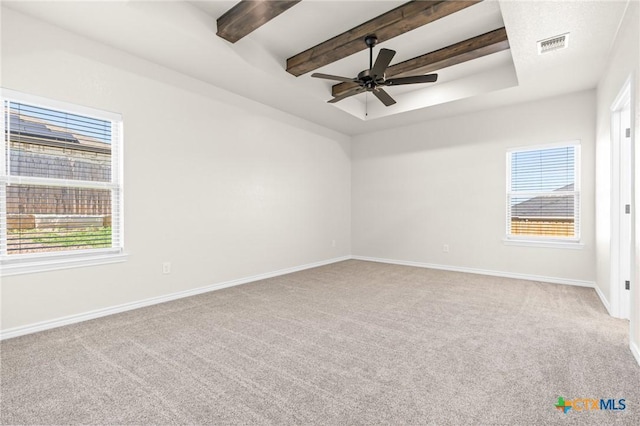 carpeted spare room featuring ceiling fan, beam ceiling, and a raised ceiling