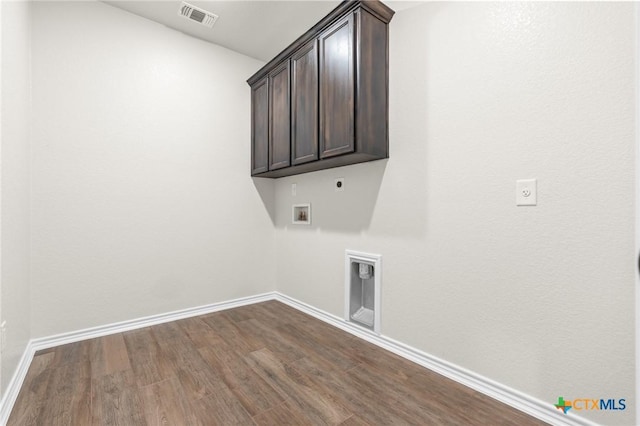 clothes washing area featuring electric dryer hookup, wood-type flooring, cabinets, and washer hookup