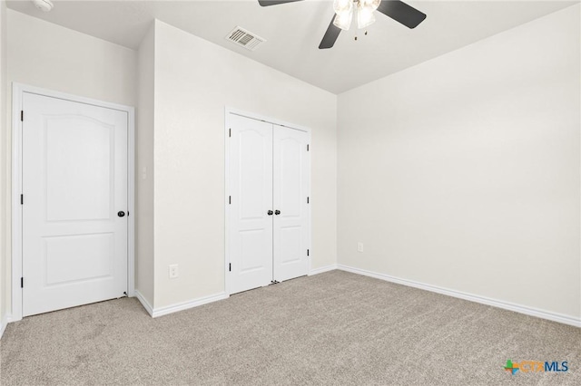 unfurnished bedroom featuring ceiling fan, a closet, and light carpet