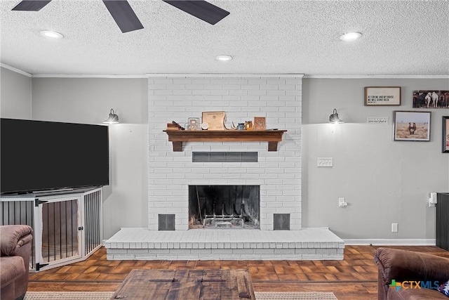 living room featuring a fireplace, ceiling fan, crown molding, and a textured ceiling