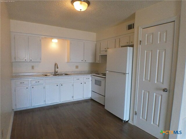 507 Hackberry St, Copperas Cove, TX 76522 - kitchen featuring white appliances, a textured ceiling, dark wood-style floors, white cabinets, and light countertops