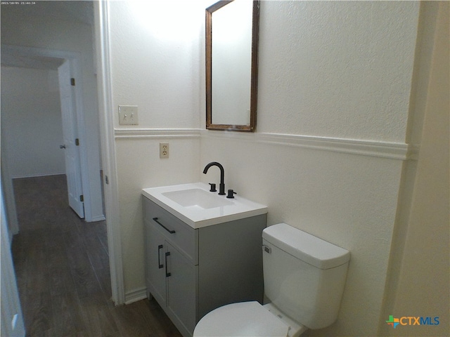 bathroom with vanity, hardwood / wood-style flooring, and toilet