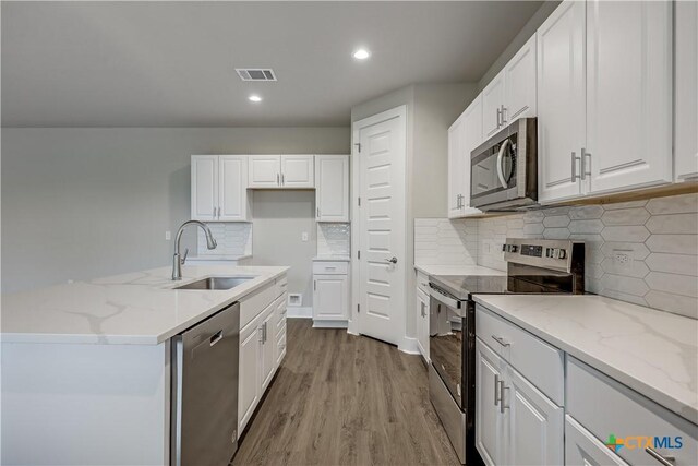 bathroom with hardwood / wood-style floors, vanity, and a shower with shower door