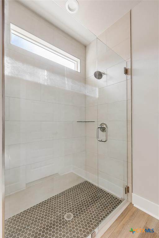 bathroom with hardwood / wood-style flooring and walk in shower