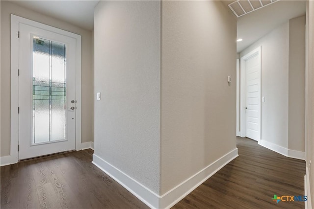 doorway to outside featuring dark wood finished floors and baseboards