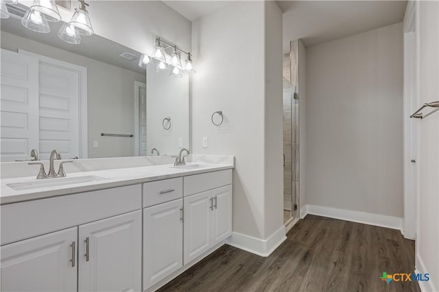 full bathroom featuring visible vents, a stall shower, wood finished floors, and a sink