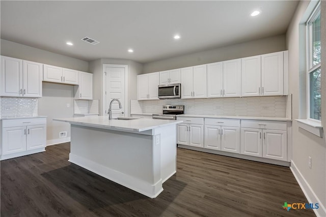 kitchen with visible vents, dark wood-type flooring, white cabinets, stainless steel appliances, and a sink