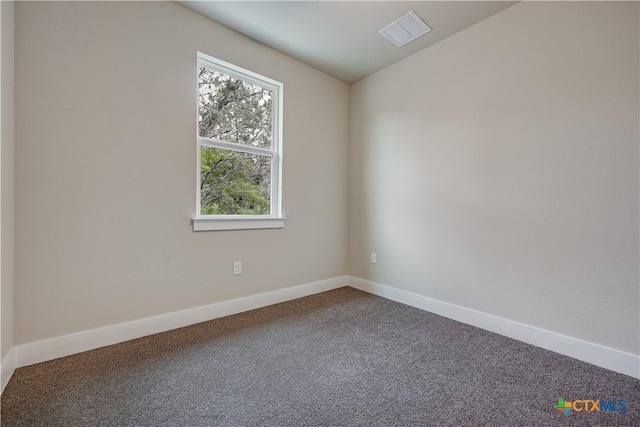 carpeted spare room with visible vents and baseboards