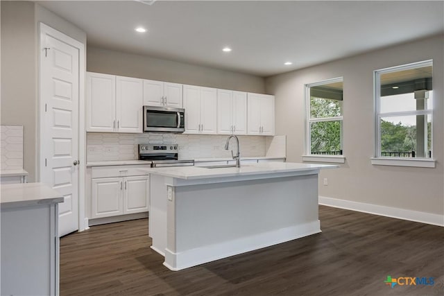 kitchen featuring dark wood-style floors, a sink, stainless steel appliances, light countertops, and white cabinetry