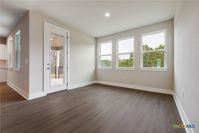 spare room with recessed lighting, baseboards, and dark wood-type flooring