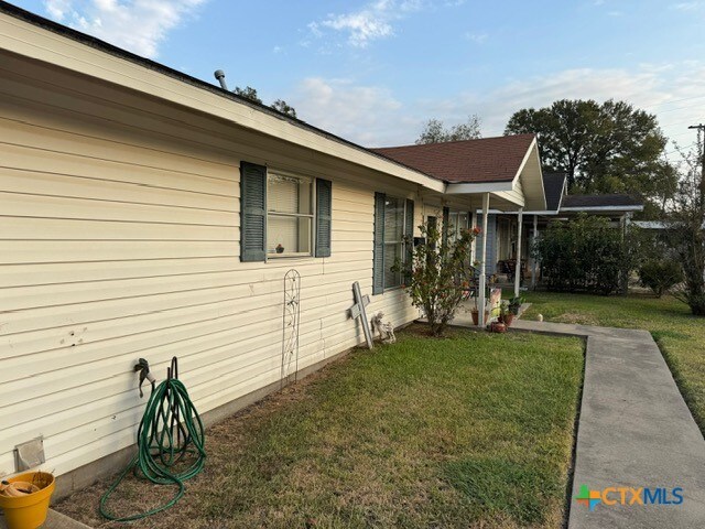 view of side of home with a yard