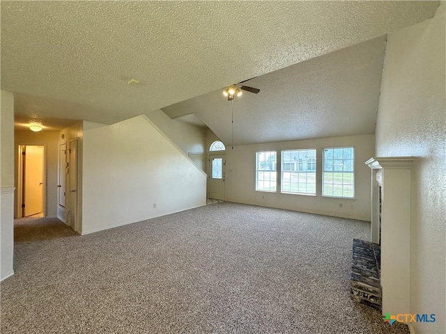 2707 Tripp Trl, Killeen, TX 76543 - unfurnished living room with a textured ceiling, carpet flooring, a ceiling fan, lofted ceiling, and a fireplace