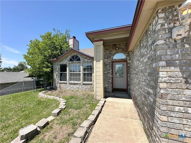 2707 Tripp Trl, Killeen, TX 76543 - view of exterior entry featuring brick siding and a chimney