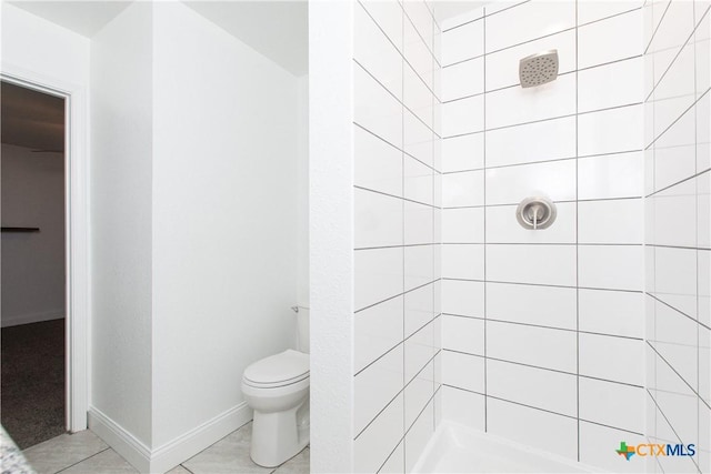 bathroom with tiled shower and toilet