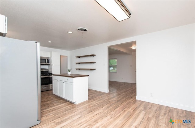 kitchen featuring appliances with stainless steel finishes, white cabinetry, and light hardwood / wood-style floors