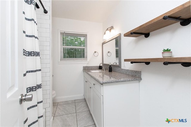 bathroom with toilet, vanity, tile patterned floors, and walk in shower