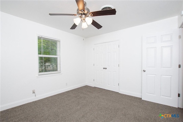 unfurnished bedroom featuring ceiling fan, a closet, and carpet flooring