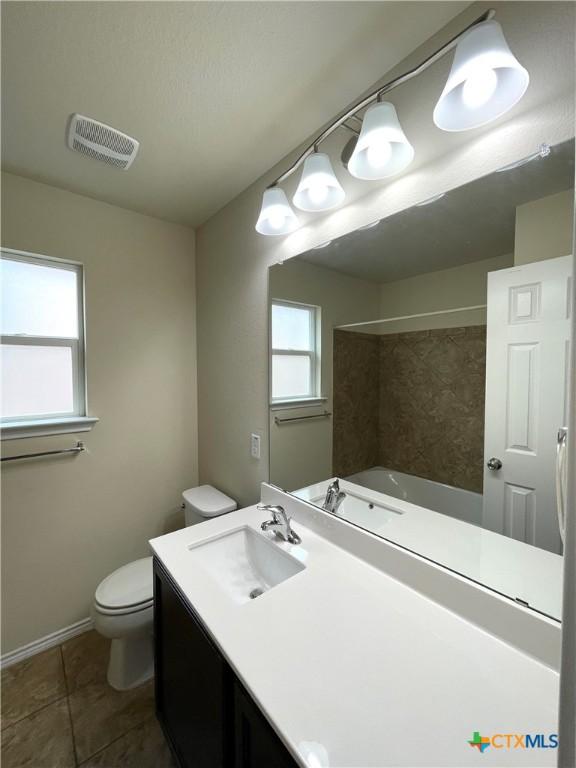 full bathroom featuring tile patterned flooring, shower / tub combination, vanity, and toilet