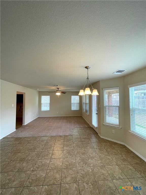 empty room featuring ceiling fan and a textured ceiling