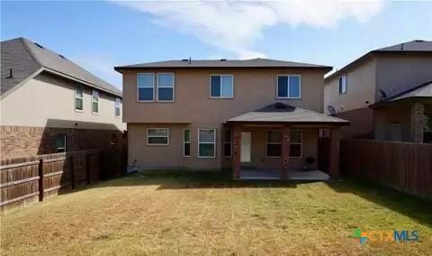 rear view of house featuring a yard and a patio area