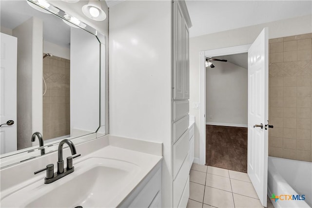 bathroom featuring tile patterned flooring, vanity, tiled shower / bath, and ceiling fan