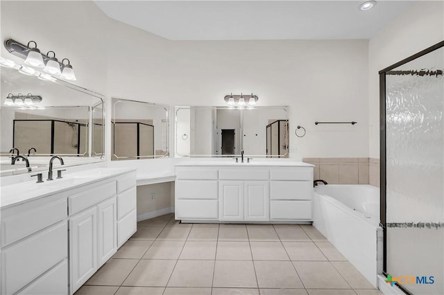 bathroom featuring a tub to relax in, tile patterned flooring, and vanity