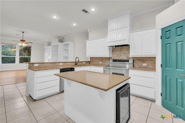 kitchen with stainless steel appliances, ceiling fan, white cabinetry, a kitchen island, and light tile patterned flooring