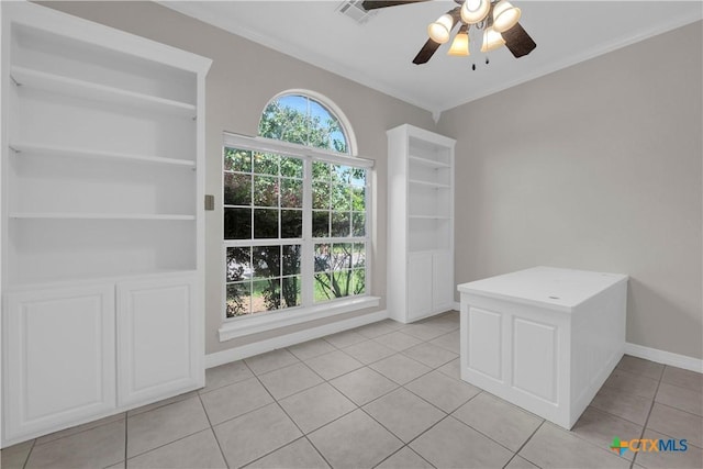 unfurnished dining area featuring ceiling fan, light tile patterned flooring, and ornamental molding