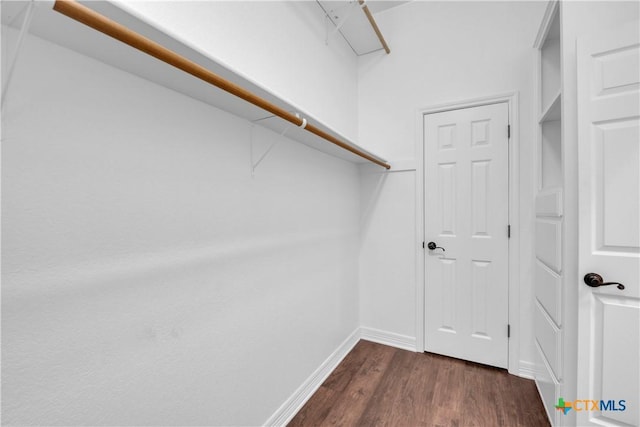 walk in closet with dark hardwood / wood-style floors