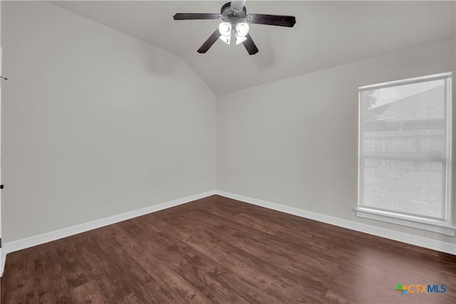 empty room featuring dark hardwood / wood-style floors, vaulted ceiling, and ceiling fan