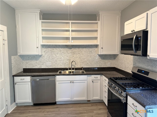 kitchen with light hardwood / wood-style floors, sink, white cabinetry, and stainless steel appliances