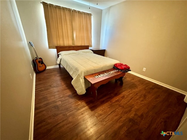 bedroom with dark hardwood / wood-style floors